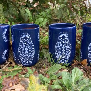 grande tasse de poterie artisanale avec un décor de poupée russe