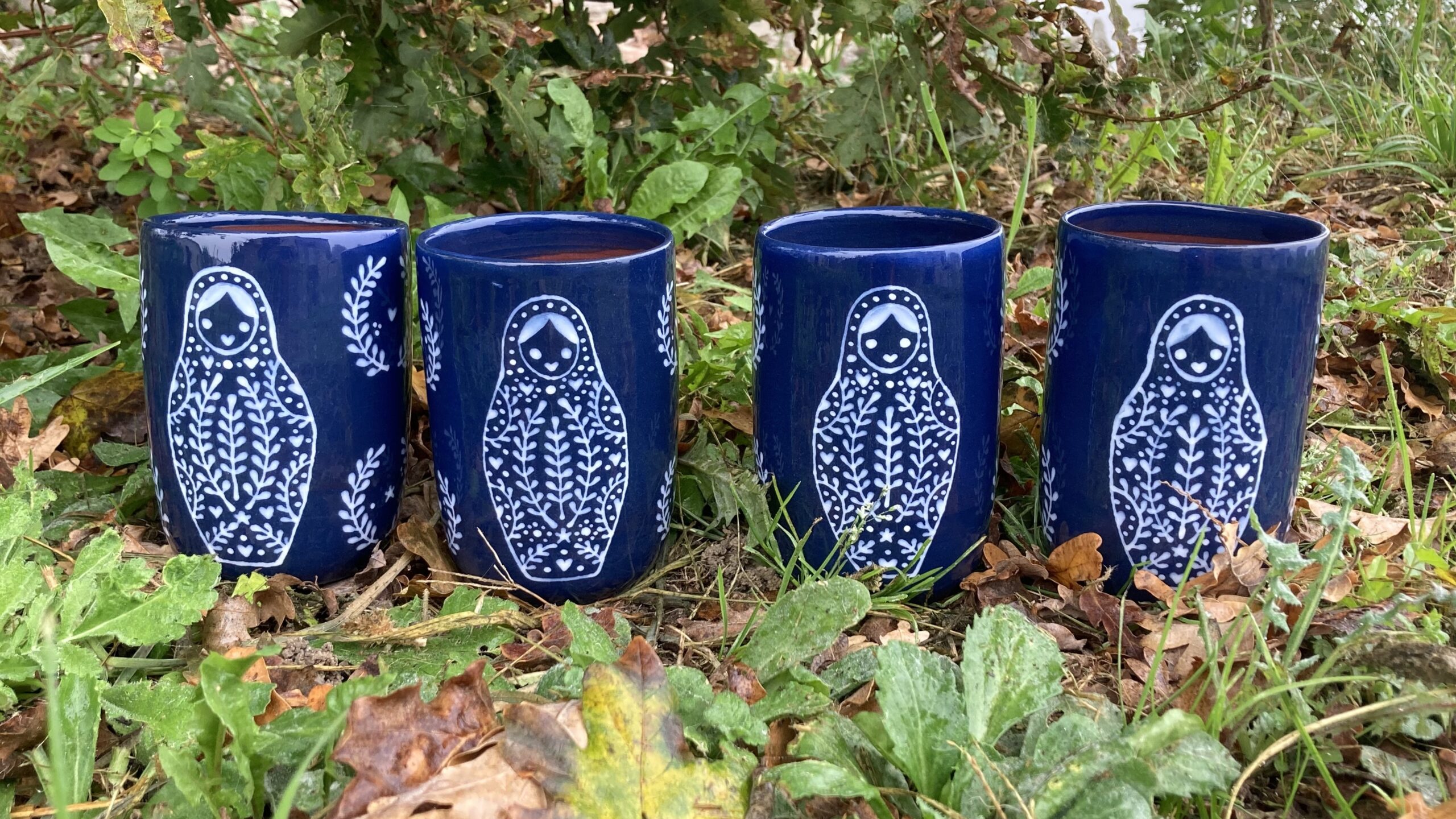 grande tasse de poterie artisanale avec un décor de poupée russe